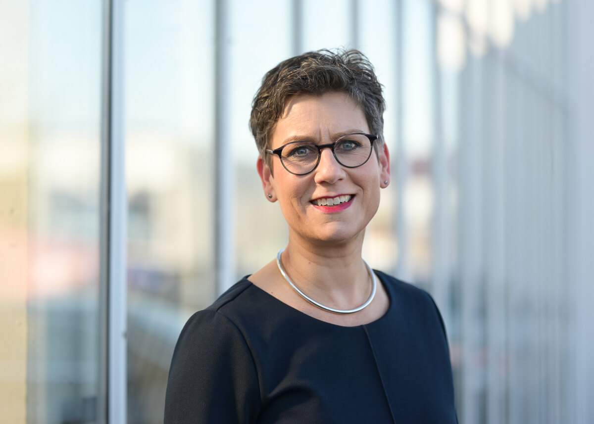 Porträtfoto von Tanja Herrmann-Hurtzig, Karriere-Coach mit Brille vor Bürofenster