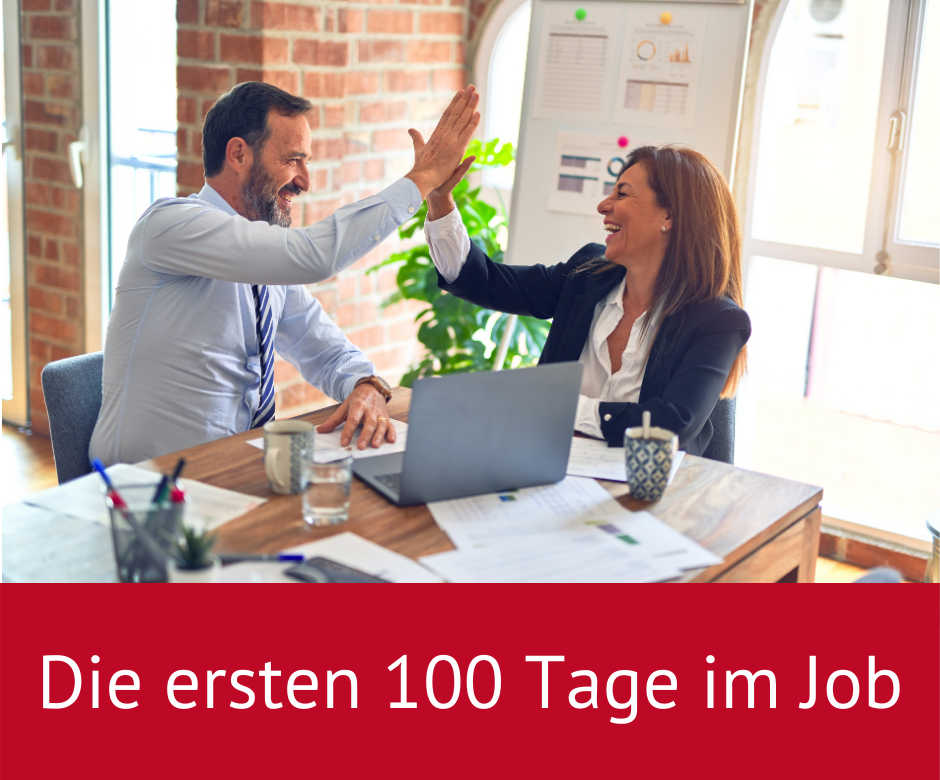 Zwei Personen geben sich High-Five im Büro, mit Laptop und Notizen auf dem Schreibtisch