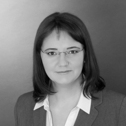 Porträtfoto einer Frau mit Brille in Geschäftskleidung, schwarz-weiß