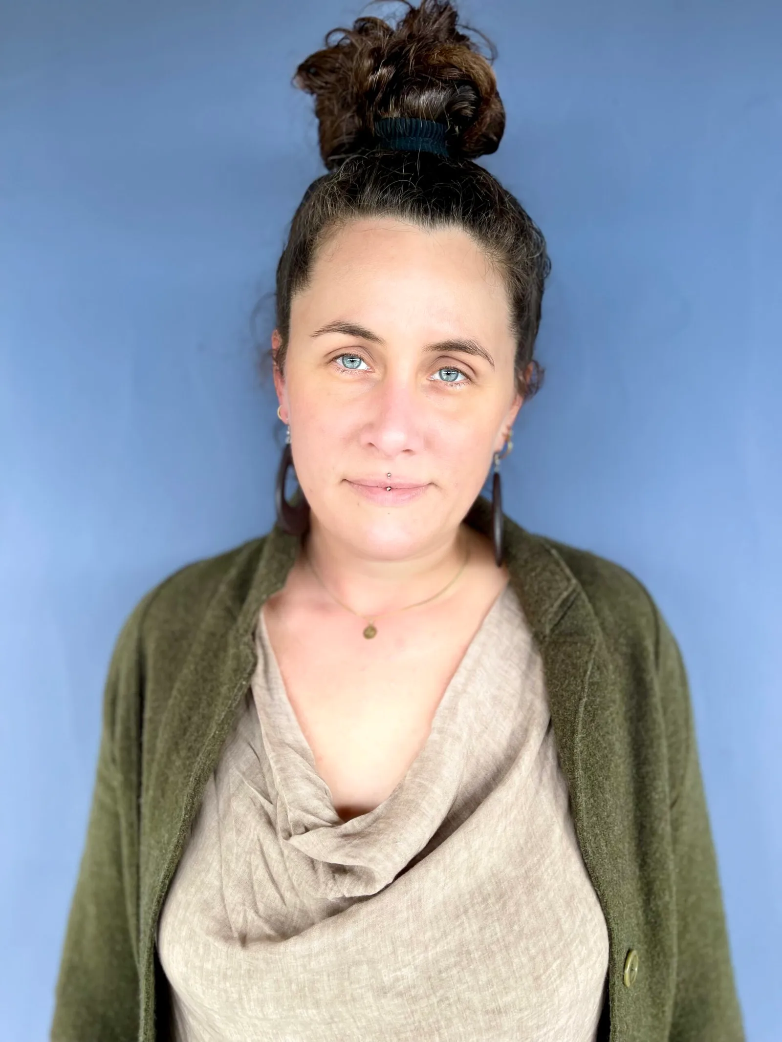Portrait Steffi Fischer mit hochgestecktem Haar vor blauem Hintergrund