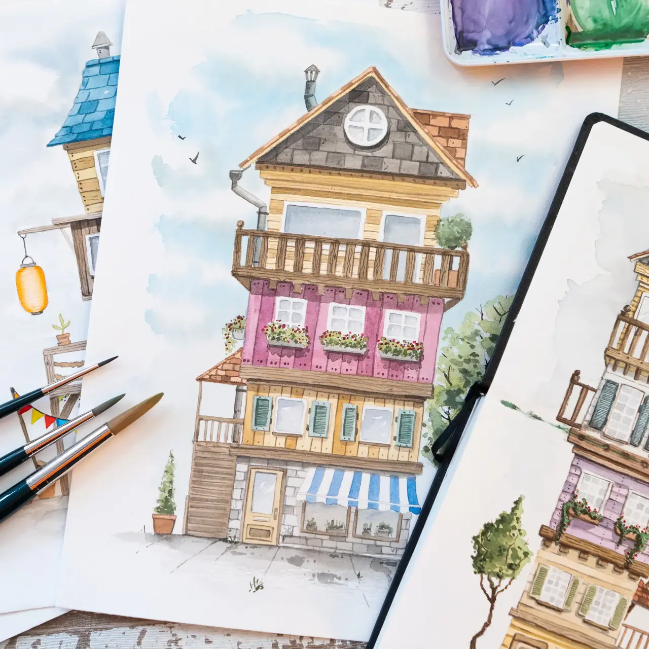 Aquarell-Illustration farbig gestalteter Fantasie-Häuser mit Pinseln und Farben