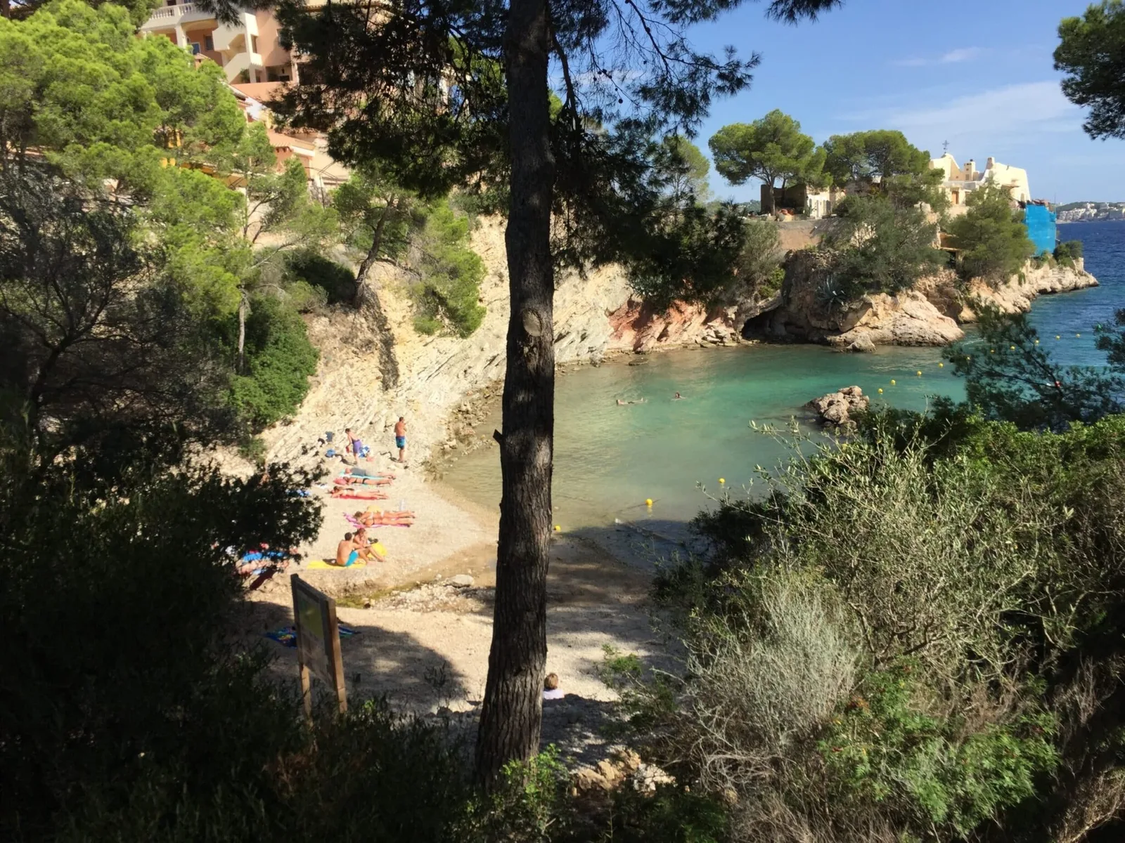 Mallorca Küstenbucht mit türkisblauem Wasser, Sandstrand und mediterranen Häusern