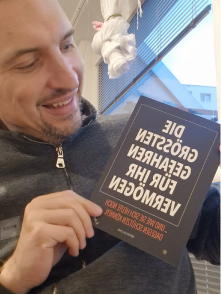 Kundenfoto: Mann hält Buch 'Die größten Gefahren für Ihr Vermögen' in Händen