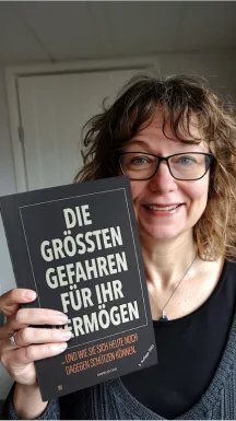 Kundenfoto: Frau mit Brille präsentiert Buch 'Die größten Gefahren für Ihr Vermögen'