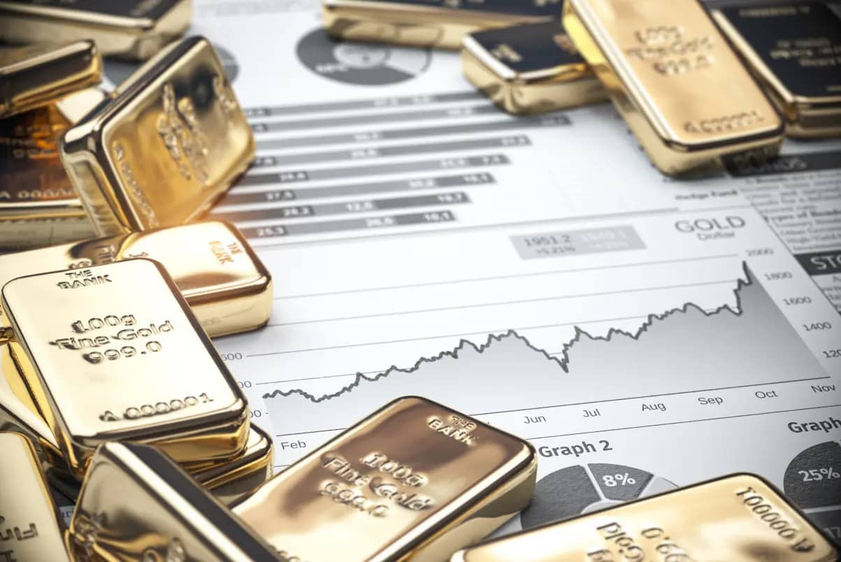 Goldbarren auf Finanzdiagrammen mit Kursverlauf und Kennzahlen
