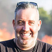 Die HerbstOffensive 2025 – Live-Workshops zum Experten-Funnel 20 Lächelnder Mann mit dunklen Haaren und Bart vor verschwommenem Hintergrund, Nahaufnahme-Porträt