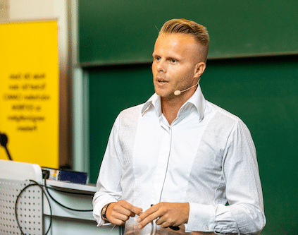 Gunnar Kessler präsentiert in weißem Hemd vor grüner Tafel, interne Blaupause für Internet-Millionär