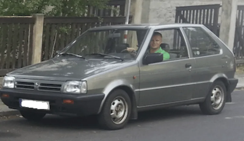 Mann sitzt in grauem Auto, Lifestyle-Foto zur Erfolgsgeschichte