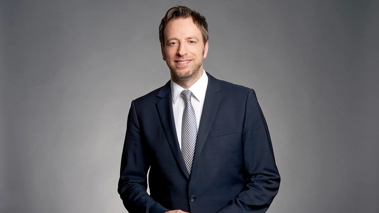 René Renk, Autor von Digitales Einkommen – Die Erfolgsakademie, in dunklem Anzug mit Krawatte