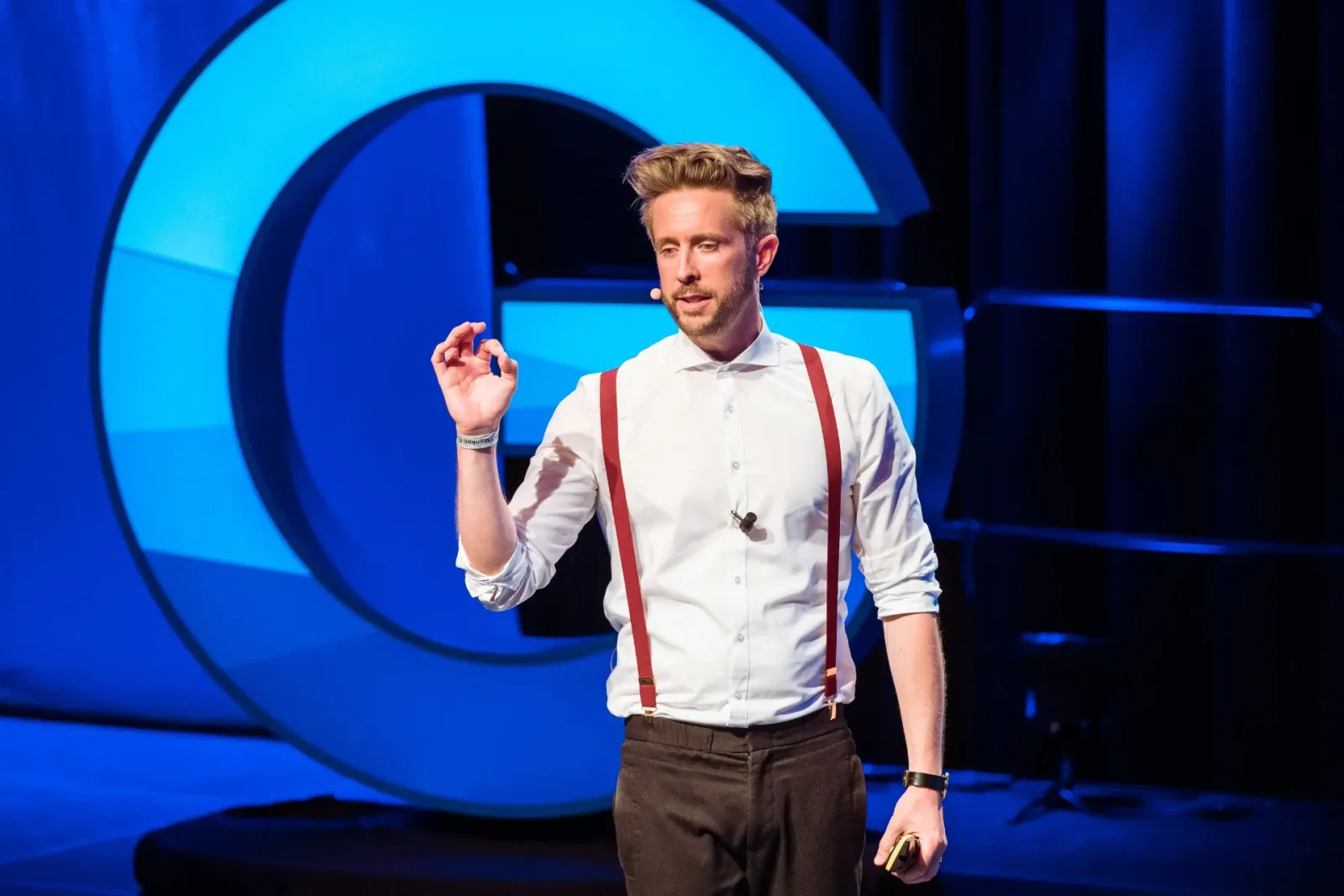 Felix Thönnessen auf Bühne vor großem blauen Kreis-Design