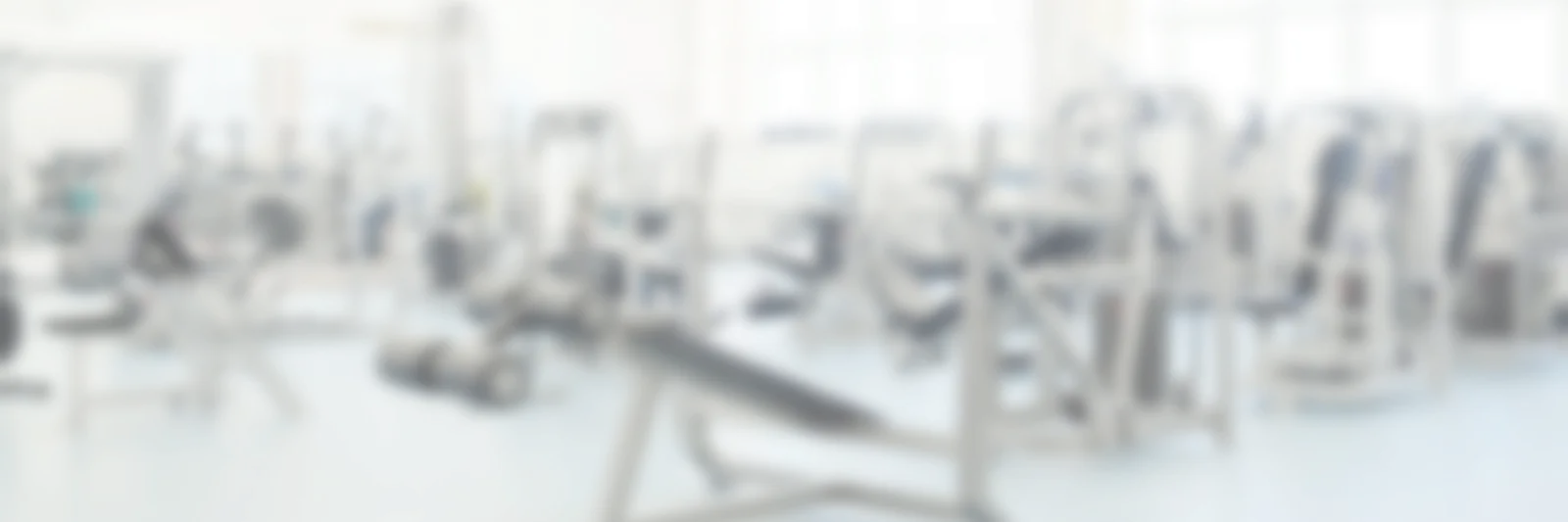 EasyActivePlus – Videokurs für aktiven Lebensstil 3 Unscharfer Hintergrund einer modernen Trainingshalle oder Fitnessstudio mit Geräten