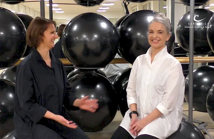Einführung in die CANTIENICA®-Methode von Benita Cantieni 5 Zwei Frauen im CANTIENICA-Studio mit schwarzen Gymnastikbällen, Gespräch während Training
