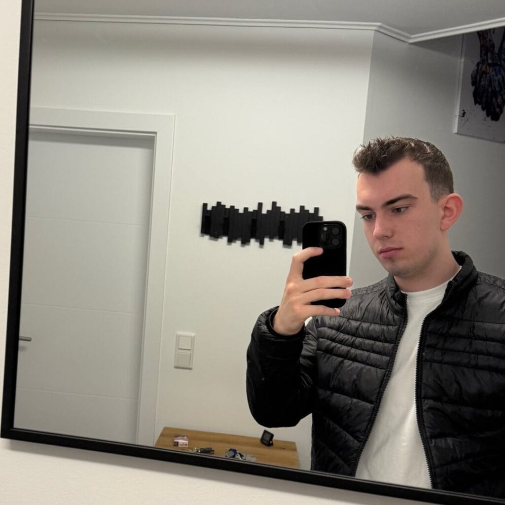 Julian Spiegelselfie mit Smartphone vor Whiteboard