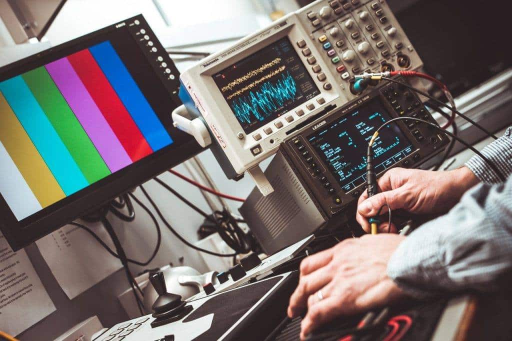 Elektrotechnik-Arbeitsplatz mit Testgerät, Bildschirm mit Testmuster und Messinstrument
