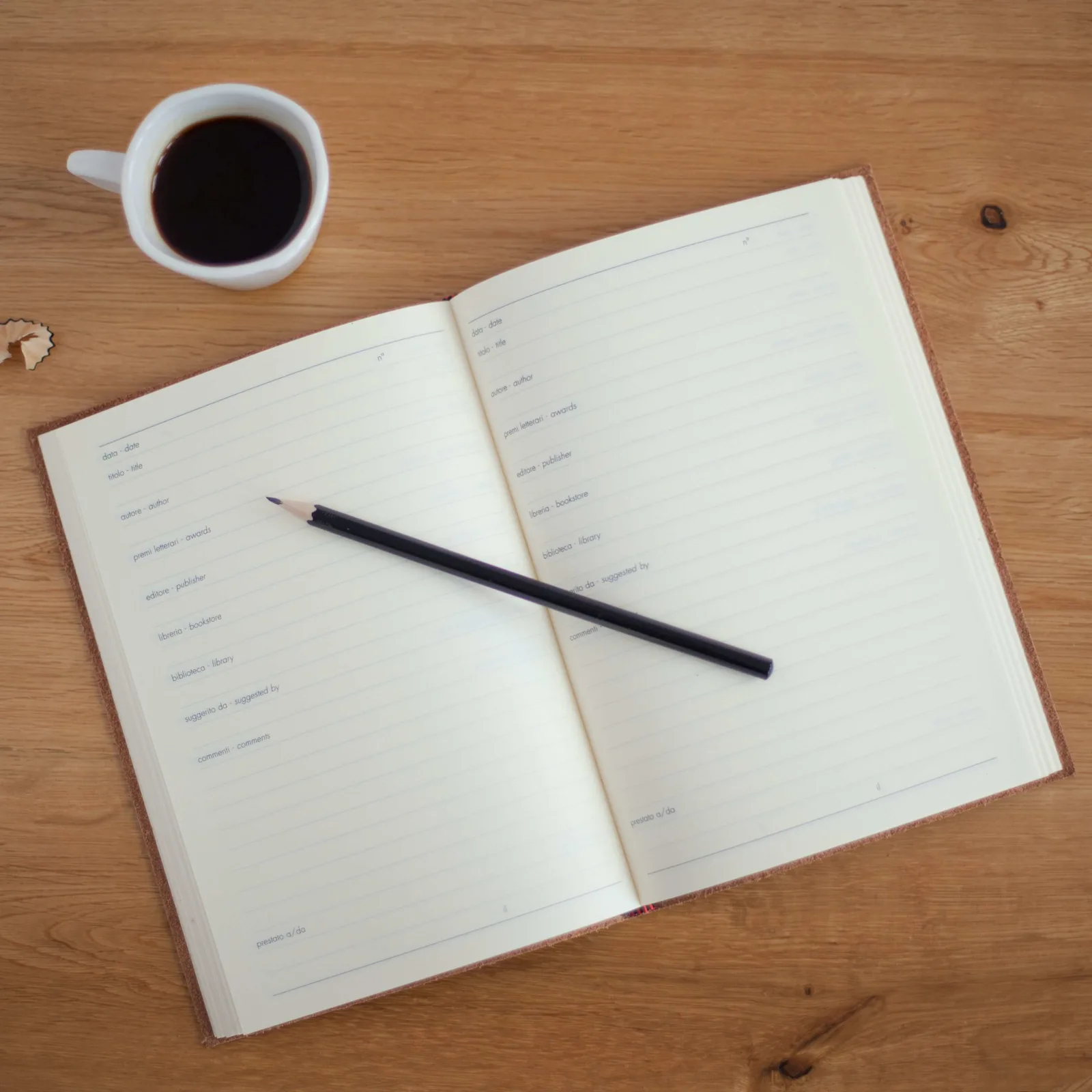Elternworkshop – Wie motiviere ich mein Kind zum Lernen? 8 Notizbuch, Stift und Kaffeetasse auf Holztisch von oben