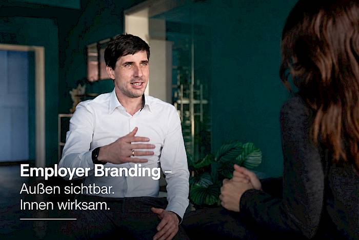 Mann im weißen Hemd in Gesprächssituation mit Textoverlay zum Employer Branding Online-Impuls