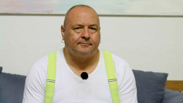 Porträt Frank Künster mit weißem T-Shirt und neongelben Trägern