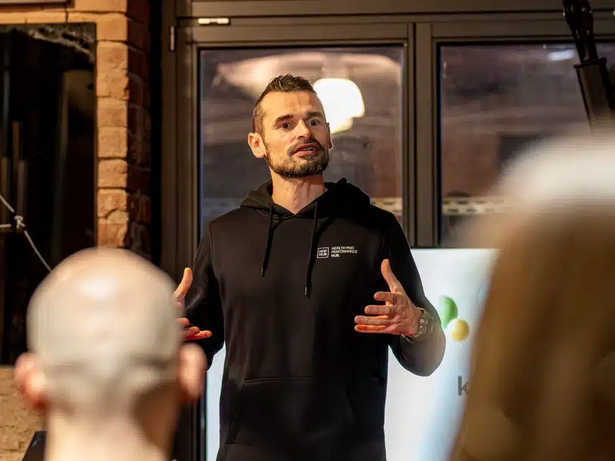 Stefan Liebezeit spricht während eines Events vor Publikum im schwarzen Hoodie