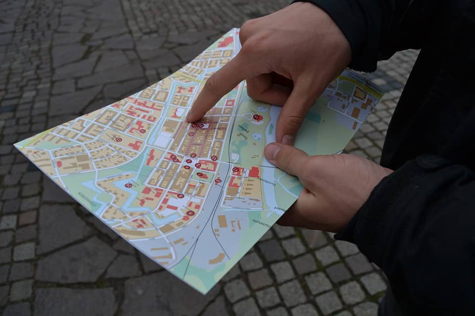 Zwei Hände halten eine Wanderkarte mit roten Markierungen, symbolisiert Fokus und Zielplanung