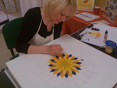 Energiebilder selber malen – Online Videomalkurs Mandala 23 Gelbes und blaues Mandala-Kunstwerk mit Blätter-Muster auf weißem Papier