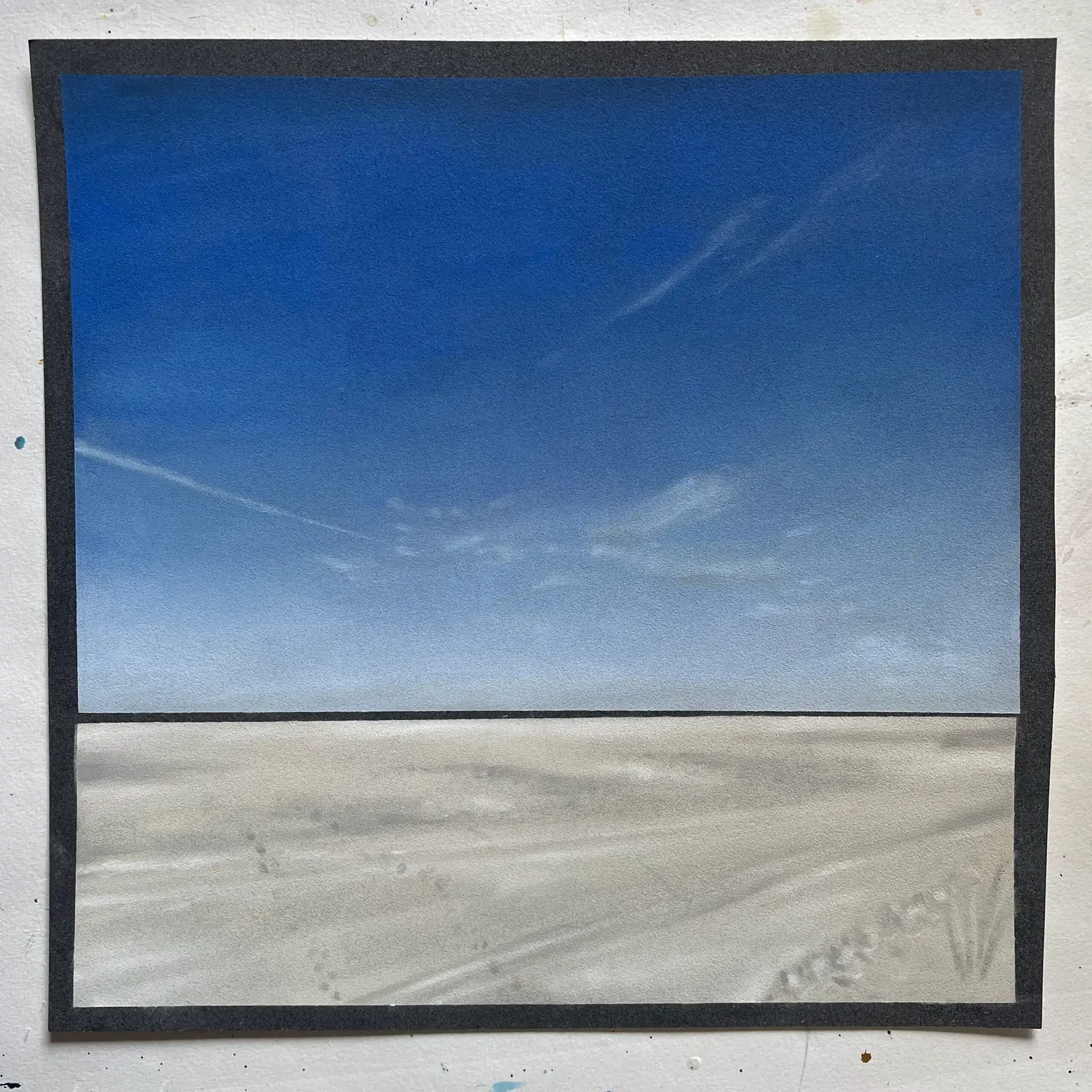 Gemaltes Bild mit schwarzem Rahmen zeigt Strand und blauen Himmel
