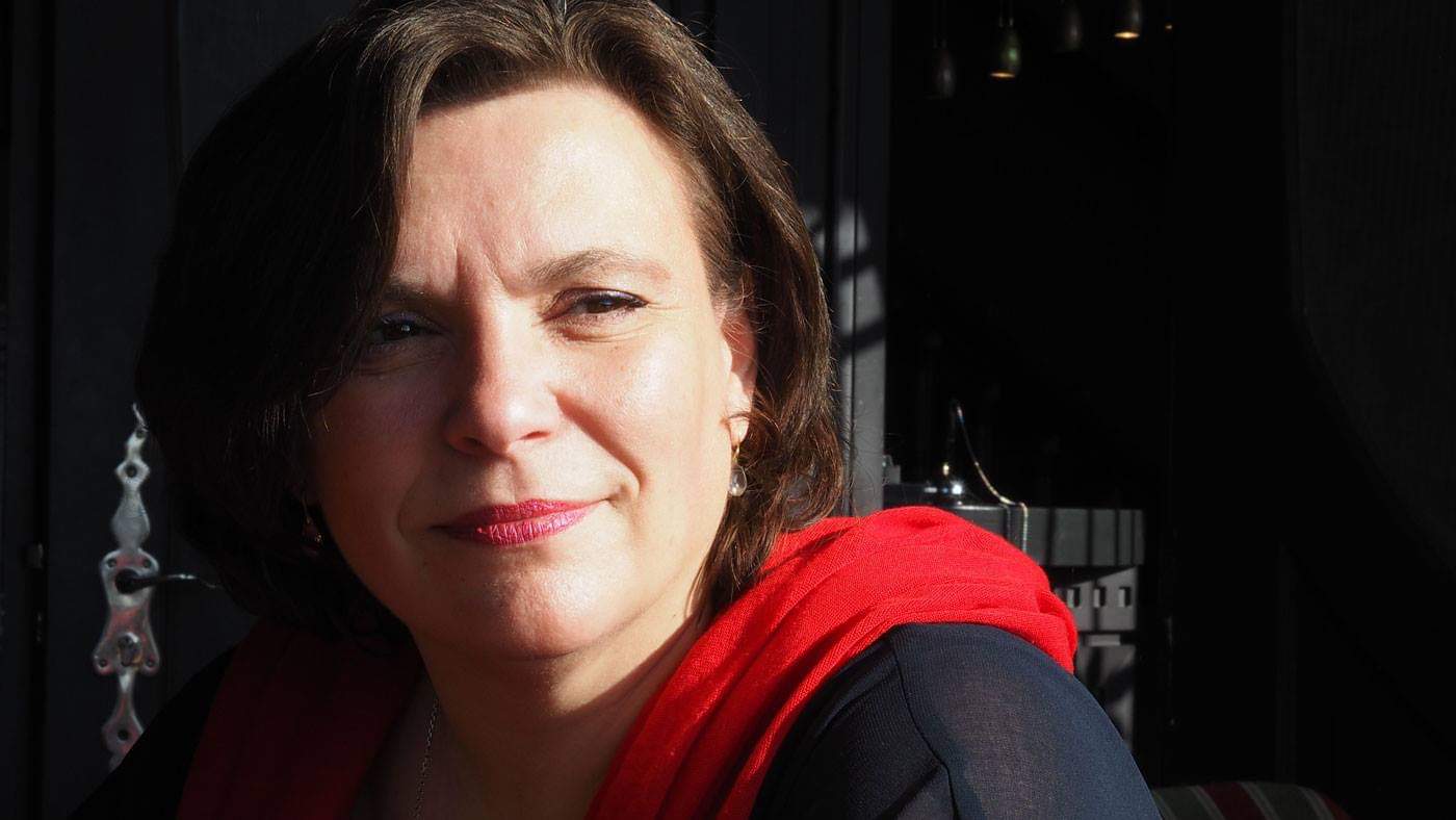 Christine Hofmann Portrait mit rotem Schal vor dunklem Hintergrund