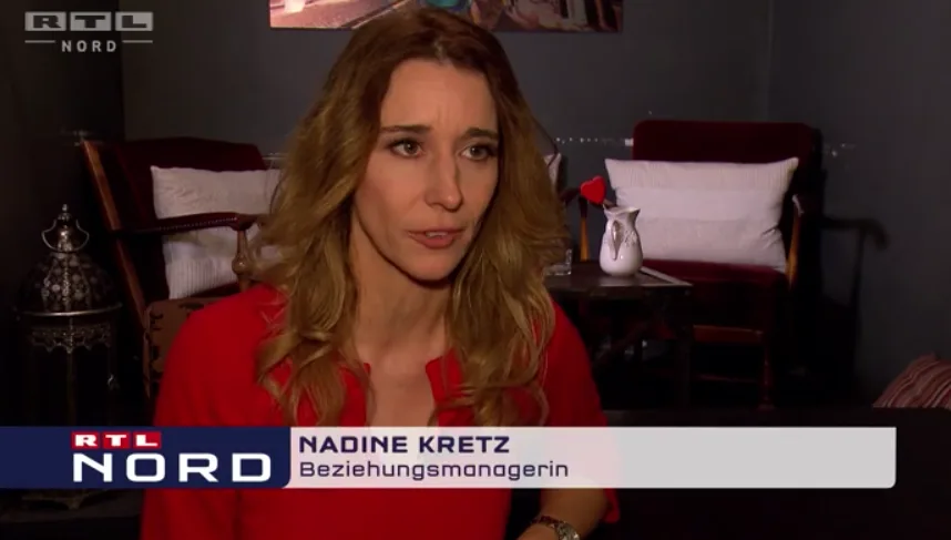 Nadine Kretz als Beziehungsmanagerin in RTL Nord Nachrichtenformat im roten Outfit