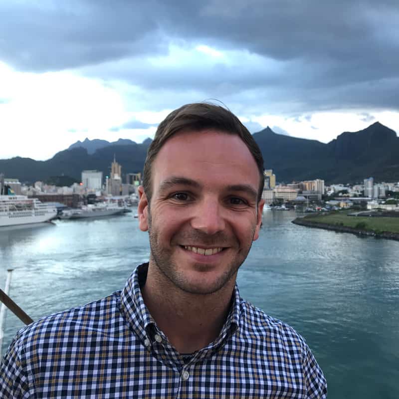 Porträt Sebastian Klugstedt mit Hafenblick und Bergkulisse im Hintergrund