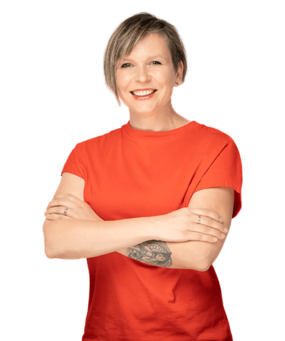 Porträt Romy Oswald vor türkisem Hintergrund mit verschränkten Armen