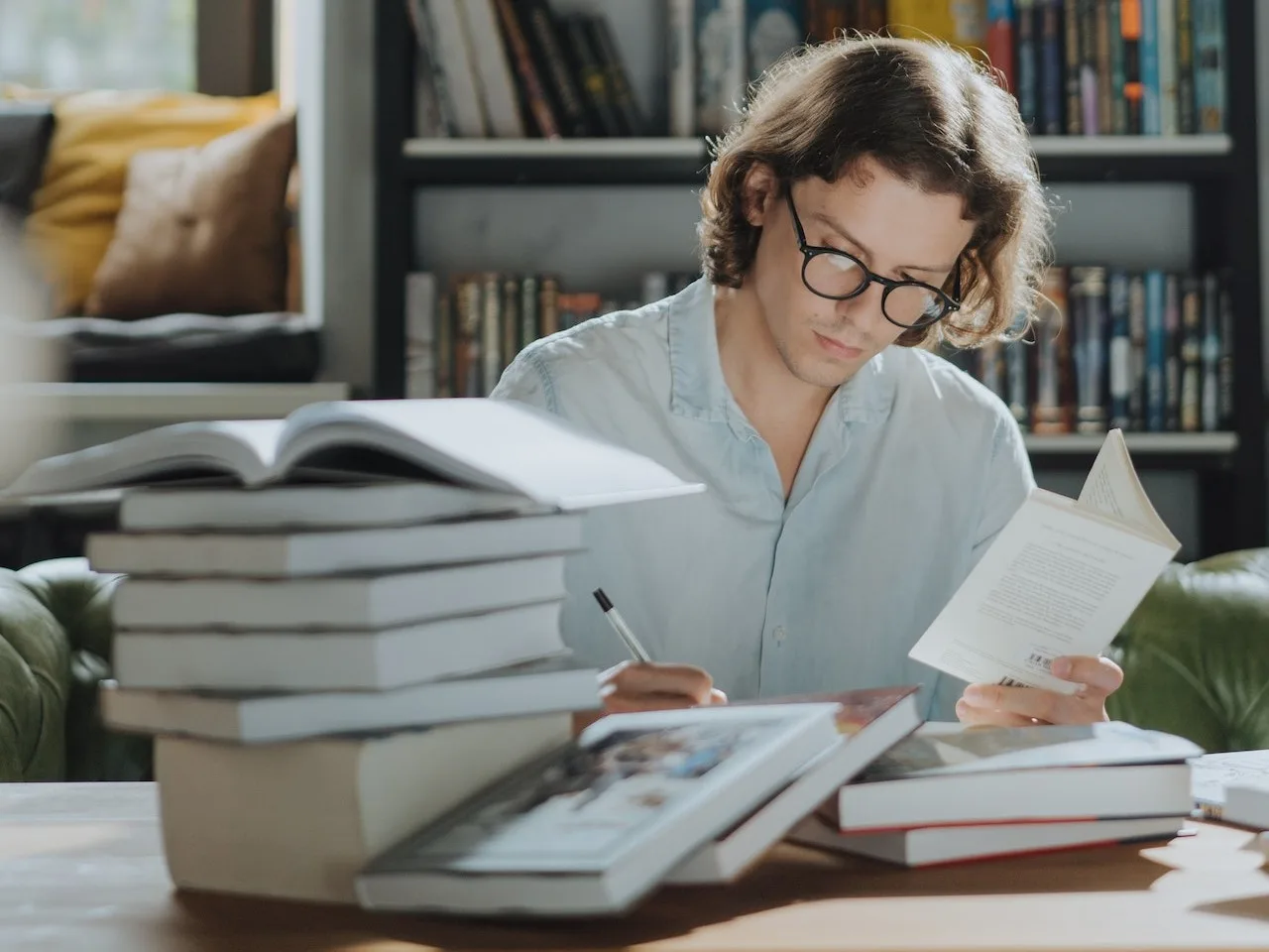 Frau mit Brille lernt in Bibliothek mit Bücherstapeln