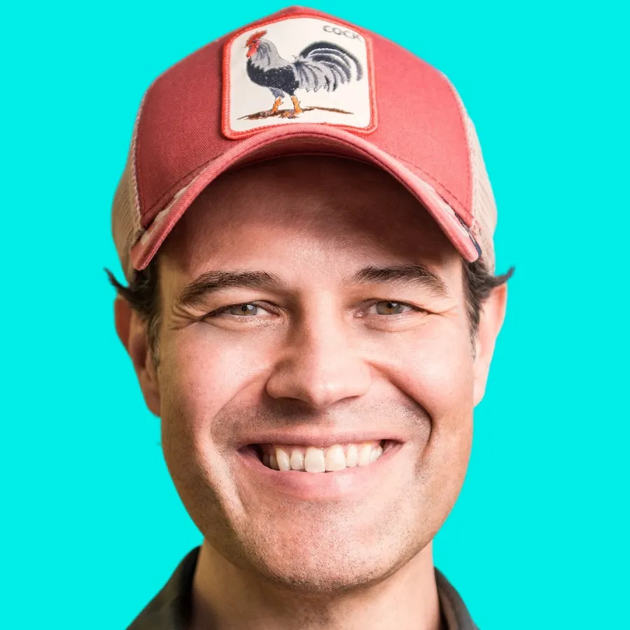 Mann mit roter Basecap und Hahn-Logo vor türkisem Hintergrund