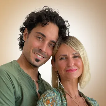 Portrait von zwei lächelnden Personen vor beigem Hintergrund