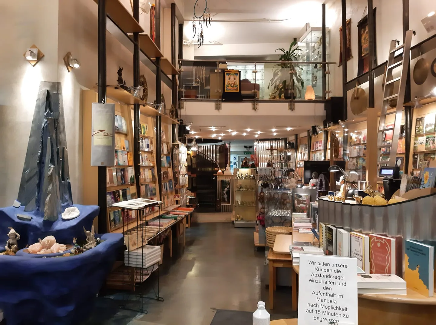Innenaufnahme eines esoterischen Buchladens mit Regalen, Displays und ausgestellten Flyern an den Wänden