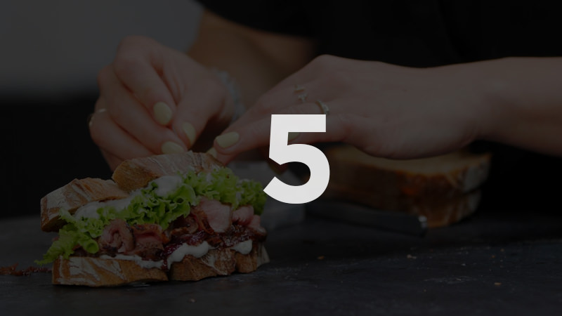 Hands preparing a sandwich with lettuce and meat on bread, Modul 5 Food Fotografie