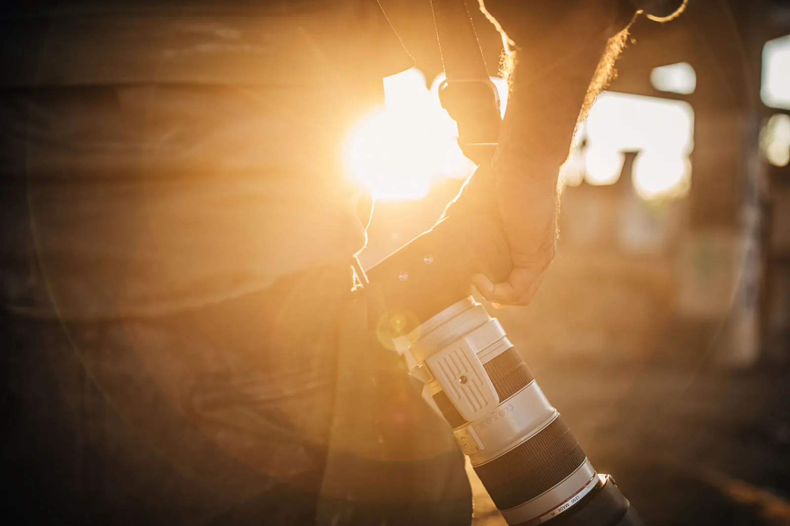 Hände halten Teleobjektiv gegen Sonne mit Lichteffekten und Bokeh im Hintergrund