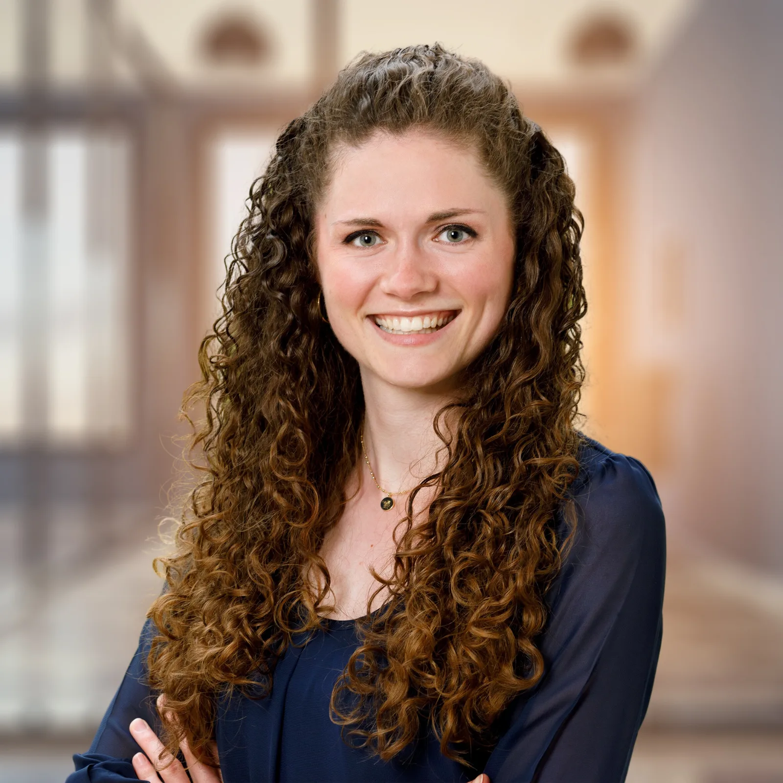 Professionelles Porträt von Franziska Haberl mit lockigen Haaren, dunklem Oberteil