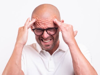 Markus Rimser fasst sich an Kopf, Schmerz-Geste, weißes Hemd, Brille