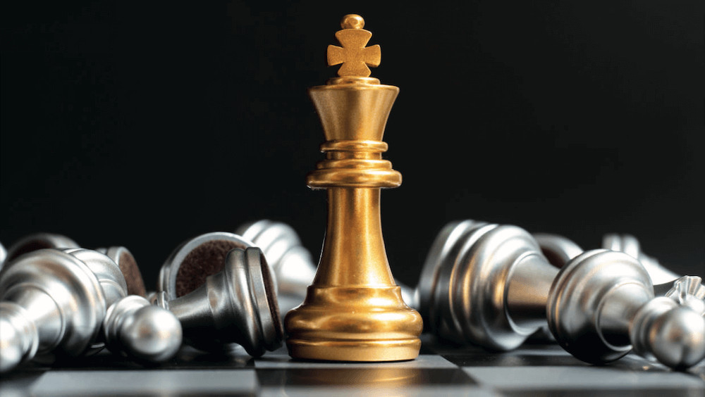 Traders Magazin Artikel mit golden glänzendem Schach-König und silbernen umgestürzten Figuren
