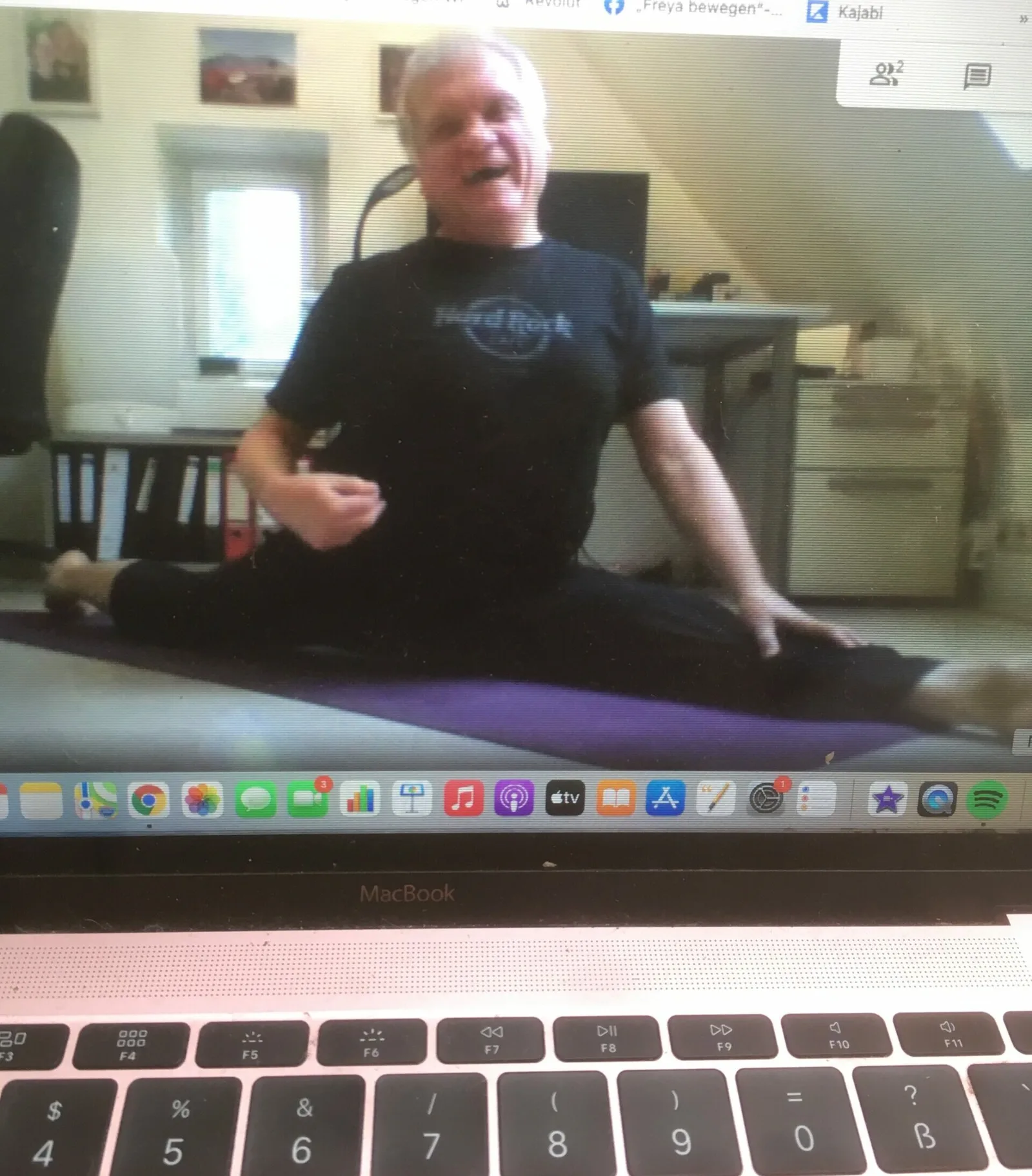 Freya's Studio – Yoga- und Stretching-Videokurse von Freya bewegen 6 älterer Mann sitzt auf Matte und trainiert per Videokonferenz