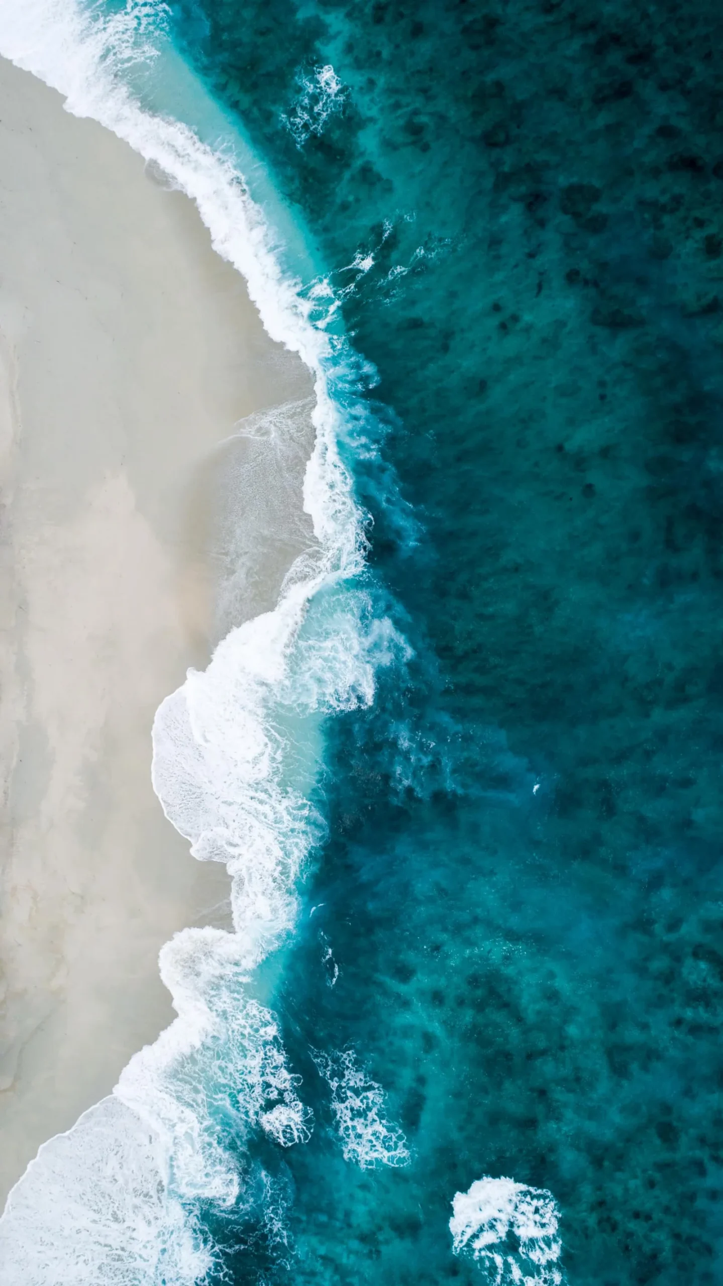 Luftaufnahme Küstenlinie mit türkisfarbenem Meer und weißem Sandstrand