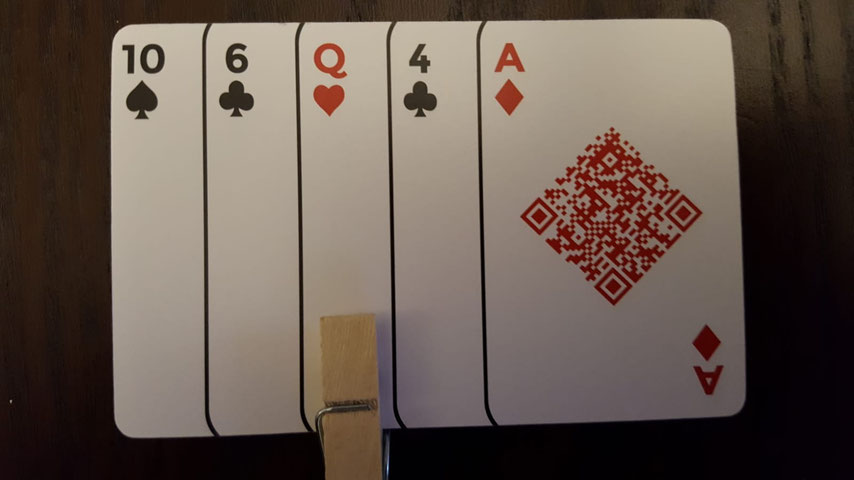 Fünf Spielkarten mit Buchstabe A und Symbolen auf Holztisch