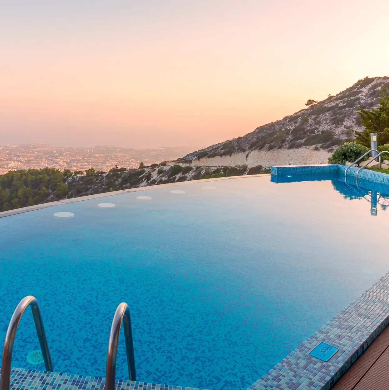 Infinity-Pool an Berghang mit Sonnenuntergang, luxuriöses Lebensstil-Symbol