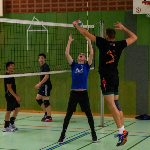 Volleyball-Spieler bei Warm-Up-Spielen am Netz in Sporthalle