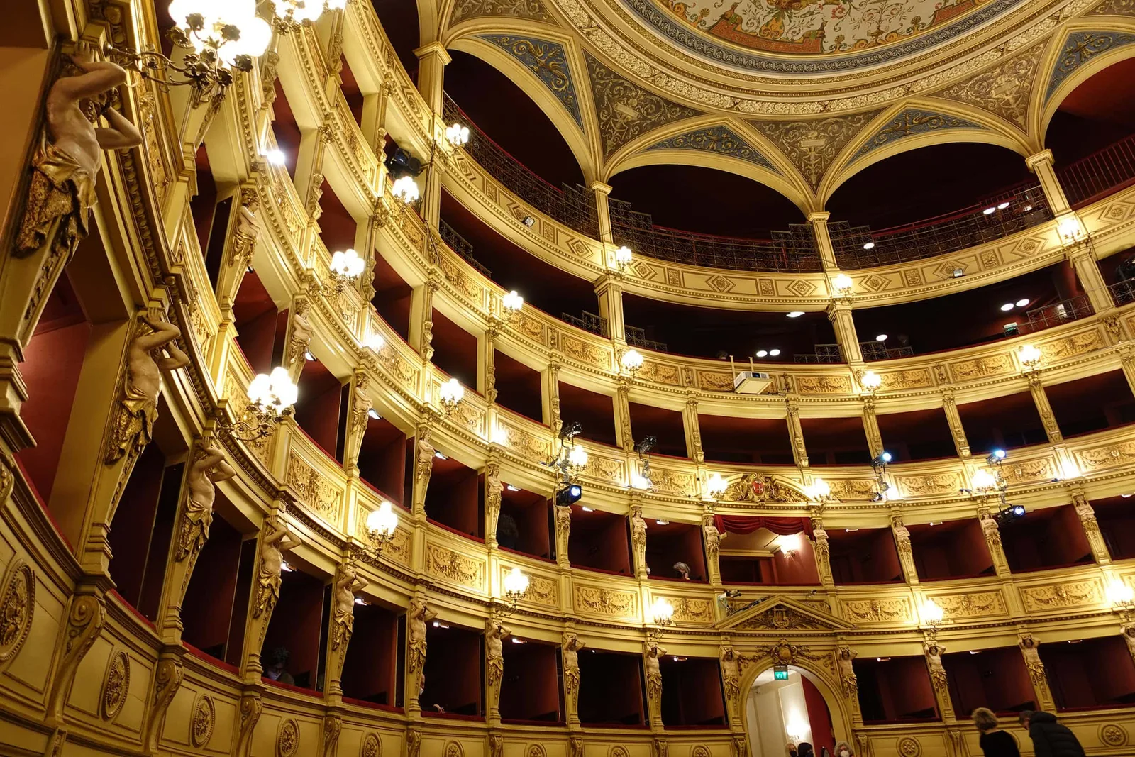 Prachtvolles Opernhaus-Interieur mit vergoldetem Stuck, roten Samtkissen und eleganter Beleuchtung