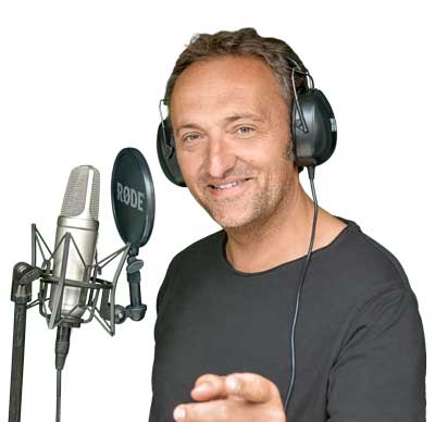 Matthias Ernst Holzmann mit Kopfhörern vor Studiomikrofon, schwarzes T-Shirt