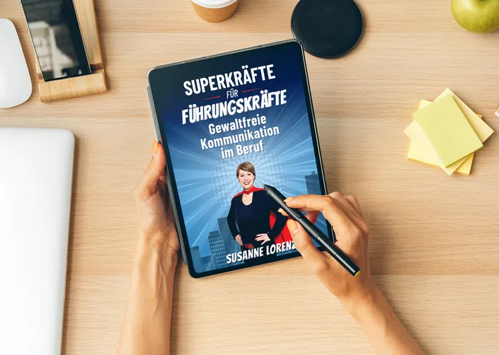 Tablet-Mockup: E-Book 'Superkräfte für Führungskräfte - Gewaltfreie Kommunikation im Beruf' von Susanne Lorenz auf Holztisch