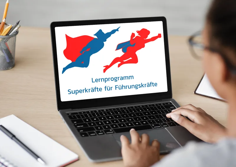 Laptop-Bildschirm zeigt Online-Lernprogramm Gewaltfreie Kommunikation mit Superhelden-Illustration