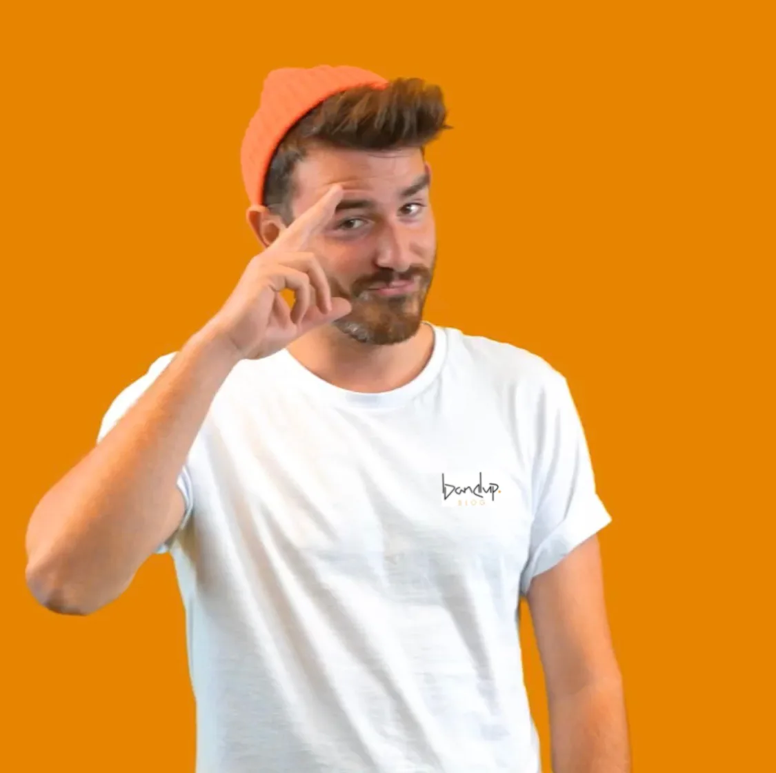 Mann mit Hut vor orangegelbem Hintergrund mit Hand am Kopf