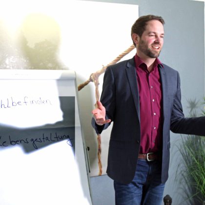 Hubert Krane hält Baseball-Schläger vor Whiteboard mit Notizen