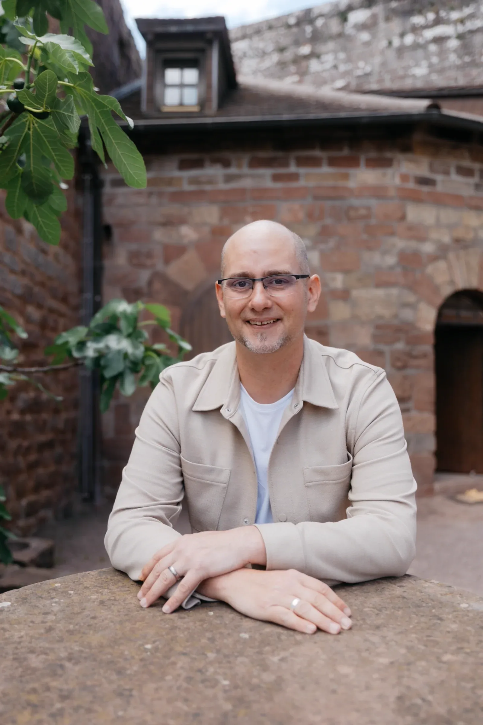 Pascal Schildknecht, Mitgründer der Sales Angels, Portrait vor Backsteinmauer mit Efeu